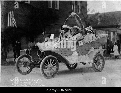 Ein dekoriertes Auto, das in den 1910er Jahren an der Karnevalsparade des Mardi Gras in Apalachicola, Florida, teilnahm Das Bild fängt die festliche Atmosphäre der Parade mit Oldtimern ein. Stockfoto