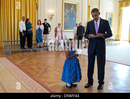 US-Präsident Barack Obama schreibt eine Notiz um Alanah Poullard fehlenden Schulabschluss zu entschuldigen, während des Besuchs mit verwundeten Krieger und ihre Familien im East Room des weißen Hauses 19. September 2013 in Washington, DC. Stockfoto