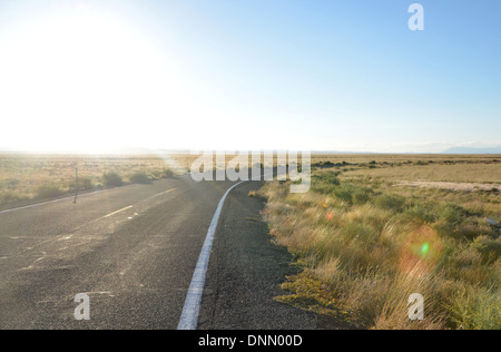 Tiefstehende Sonne über Wüstenstraße bend, Arizona, USA. Route 66-Hintergrund Stockfoto