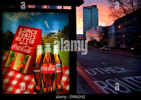 Coca-Cola Werbung Schild an der Bushaltestelle in der Abenddämmerung, Warren Street, London Stockfoto