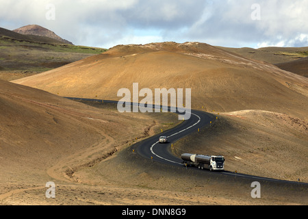 Auto und Tanker auf kurvigen Namaskard Pass zwischen den Bergen von Dalfjall und Namafjall in Nordisland Stockfoto