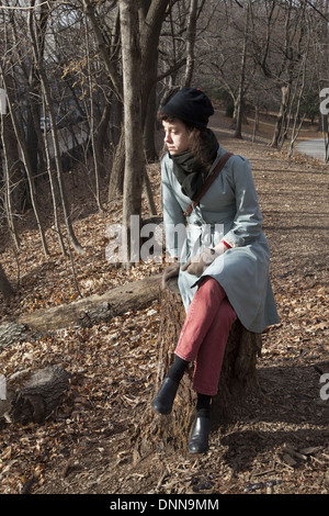 Junge Frau sitzt im Prospect Park am Weihnachtstag in Brooklyn, New York. Stockfoto