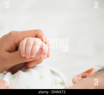 Hand der Frau halten Baby (2-5 Monate) Stockfoto