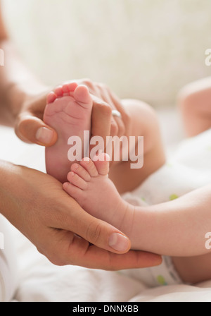Mutter hält Füße Baby boy (2-5 Monate) Stockfoto
