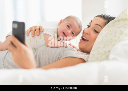 Fotografieren sich Mutter und baby Boy (2-5 Monate) mit Handy Stockfoto