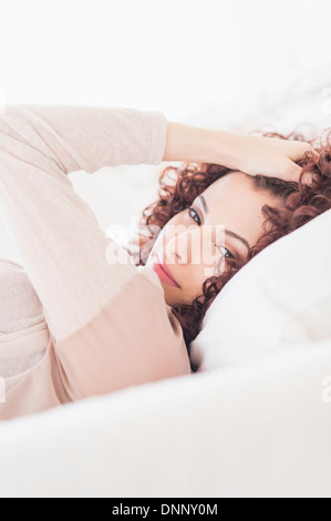 Schöne Frau im Bett liegend Stockfoto