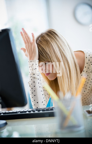 Frau leidet unter Kopfschmerzen im Büro Stockfoto