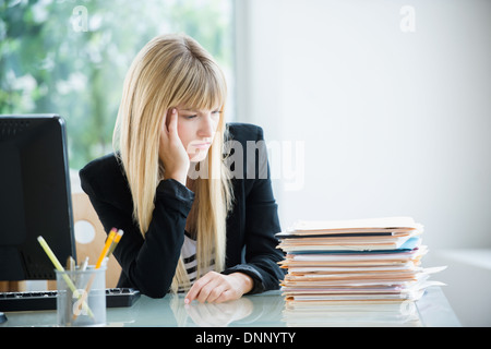 Geschäftsfrau, die Stapel von Dateien betrachten Stockfoto