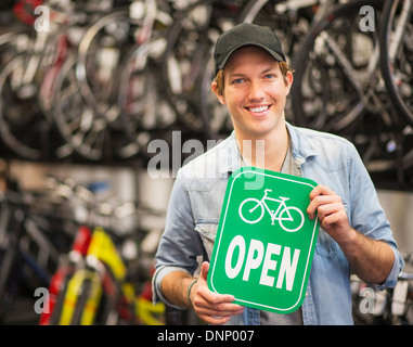 Porträt des Mannes im Bike-Shop hält Schild "geöffnet" Stockfoto