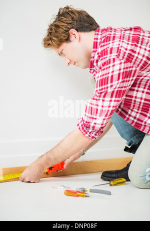 Mann-Mess-Fußleiste Stockfoto