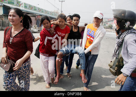 Phnom Penh, Kambodscha. 3. Januar 2014. Demonstranten tragen einen verletzten Mann bei einem Zusammenstoß in Phnom Penh, Kambodscha, 3. Januar 2014. Die kambodschanische Polizei am Freitagmorgen eröffnete das Feuer auf Arbeiter, die am Rande der Hauptstadt Phnom Penh, verlassen drei Tote und mehrere verletzte protestierten, Polizei bestätigt. Bildnachweis: Phearum/Xinhua/Alamy Live-Nachrichten Stockfoto