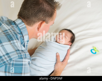 Vater Holding neugeborenen Sohn (0-11 Monate) Stockfoto