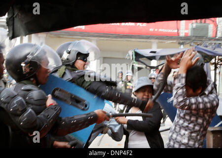 Phnom Penh, Kambodscha. 3. Januar 2014. Kambodschanische Polizei schlagen einen Kleidungsstück Stürmer in Phnom Penh, Kambodscha, 3. Januar 2014. Die kambodschanische Polizei am Freitagmorgen eröffnete das Feuer auf Arbeiter, die am Rande der Hauptstadt Phnom Penh, verlassen drei Tote und mehrere verletzte protestierten, Polizei bestätigt. Bildnachweis: Phearum/Xinhua/Alamy Live-Nachrichten Stockfoto