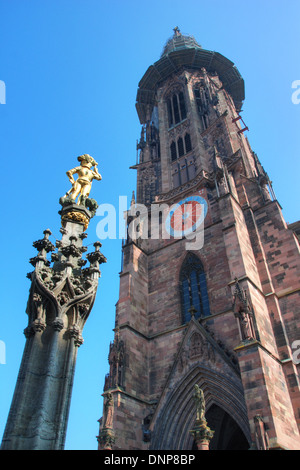 Der Turm der Freiburger Münster mit dem Brunnen im Vordergrund Stockfoto