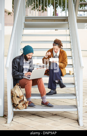 Hipster-paar mit Computer und sitzen in Treppe am Campus der Universität Essen Stockfoto