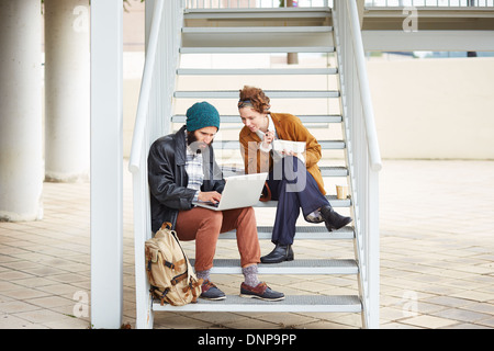 Hipster-paar mit Computer und sitzen in Treppe am Campus der Universität Essen Stockfoto