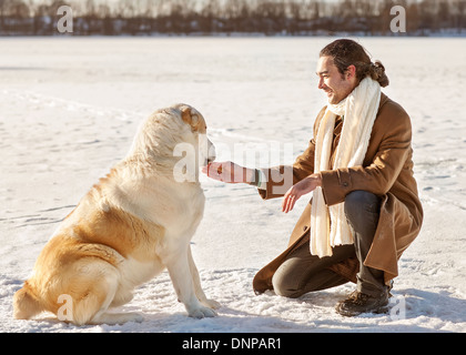 Mann und zentralasiatischen shepherd spielen mit seinem Hund im freien Stockfoto