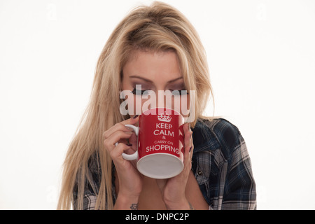 hübsche blonde Frau, die eine heiße Tasse Tee trinken Stockfoto