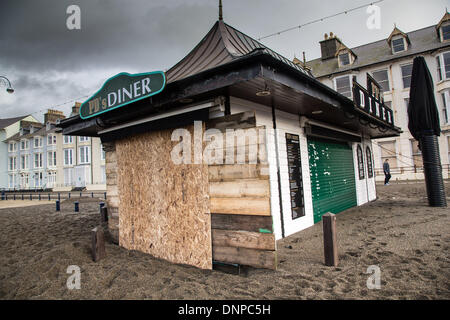 Aberystwyth, Großbritannien. 3. Januar 2014. Schäden Sie an Aberystwyth Strandpromenade. Starke Winde und eine Springflut verursacht Wellen an die Westküste von Wales zu zerschmettern. Die Promenade am Aberystwyth war für die Öffentlichkeit geschlossen, wie Wellen über den Deich Riss, brechen Küstenschutzes und Trümmer über ein weites Gebiet zu verbreiten. Polizei und Küstenwache abgesperrten im Norden und Süden Promenaden an den hohen Gezeiten, und ein Feuerwehrauto wurde gestrandet. Bildnachweis: atgof.co/Alamy Live News Stockfoto