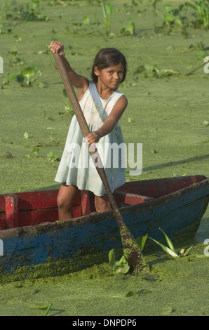 Porträt eines Mädchens im Kongo Mirador Dorf wie sie eine Boot in Zeilen Gewässern mit Lemma Pflanzen bewachsen, im Maracaibo-See, Venezuela Stockfoto