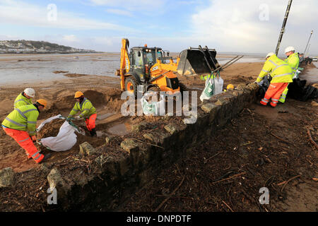 Instow, Nord-Devon, UK. 3. Januar 2014. Arbeiter stürzen, um einen Deich vor diesem Abend Flut zu Flicken, nachdem die Wand nach unten von heute Morgen Sturm in Instow, North Devon zerschlagen wurde. Bildnachweis: Joanne Roberts/Alamy Live-Nachrichten Stockfoto