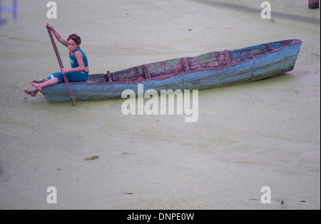 Porträt eines Mädchens im Kongo Mirador Dorf wie sie eine Boot in Zeilen Gewässern mit Lemma Pflanzen bewachsen, im Maracaibo-See, Venezuela Stockfoto