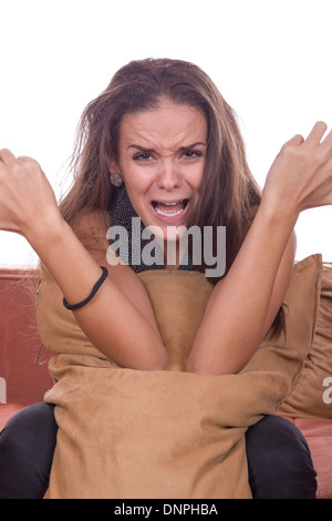 niedliche Mädchen schreien und Kissen umarmt verärgert Stockfoto