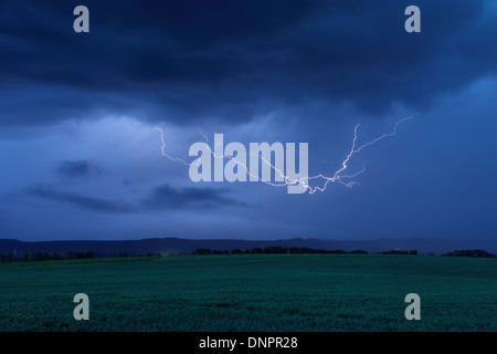 Blitze in Himmel über Feld. Bayern, Deutschland. Stockfoto