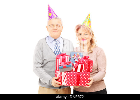 Gerne älteres Paar mit Partyhüte holding präsentiert Stockfoto