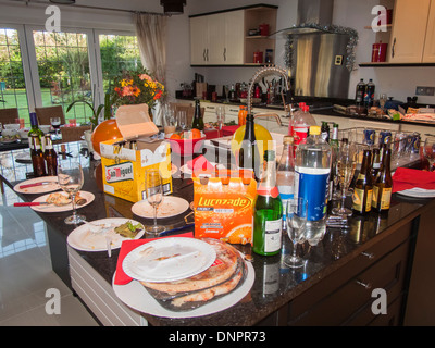 Chaotisch, unordentlich Küche nach einer Party - Wein & Bier Leerflaschen, schmutzige Pappteller, Essensreste, ungewaschenen Sektgläser Stockfoto