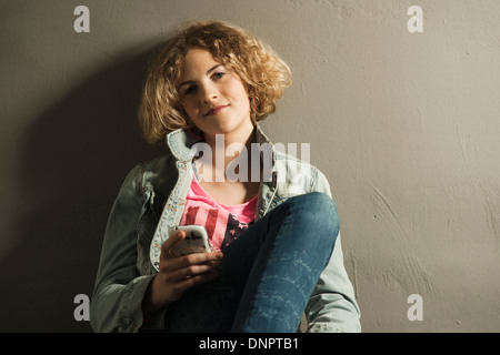 Teenager-Mädchen mit Handy, Studioaufnahme Stockfoto