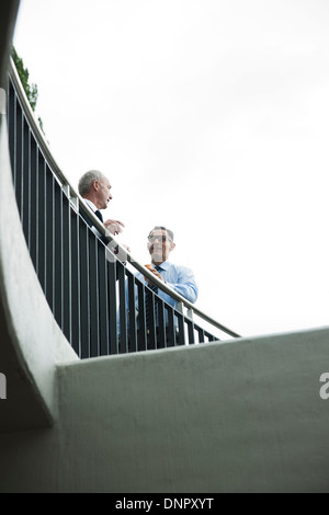 Reife Geschäftsleute auf Balkon im Freien stehen, sprechen Stockfoto