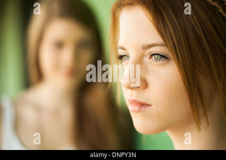 SideView Porträt von Teenager-Mädchen mit jungen Frau im Hintergrund Stockfoto