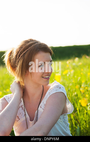 Porträt von Teenager-Mädchen sitzen im Feld, Deutschland Stockfoto