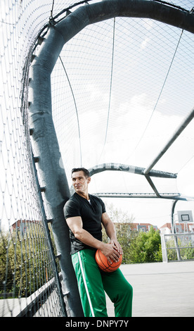 Reifer Mann steht auf Outdoor-Outdoor-Basketballplatz, Deutschland Stockfoto