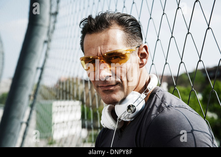 Close-up Portrait von reifer Mann mit Sonnenbrille mit Kopfhörern um Hals, Deutschland Stockfoto