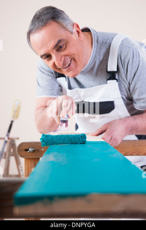 Senior woman Malerei Board mit blauer Farbe, Studioaufnahme Stockfoto