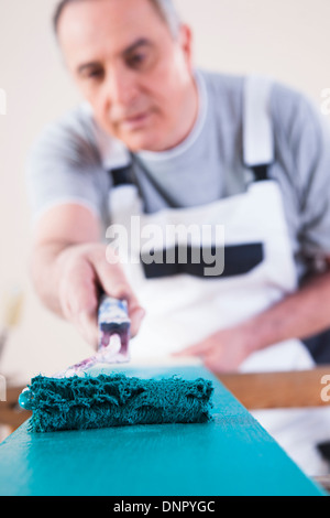 Senior woman Malerei Board mit blauer Farbe, Studioaufnahme Stockfoto