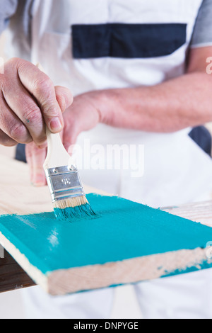 Nahaufnahme von Senior Mann-Malerei-Bord mit blauer Farbe Stockfoto