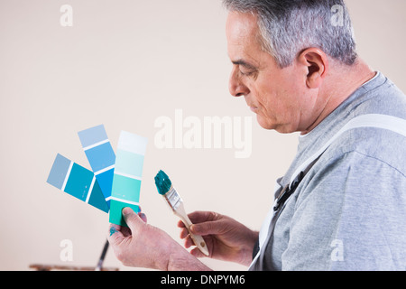 Senior-Mann betrachtet man Farbe Farbmuster, Studioaufnahme Stockfoto