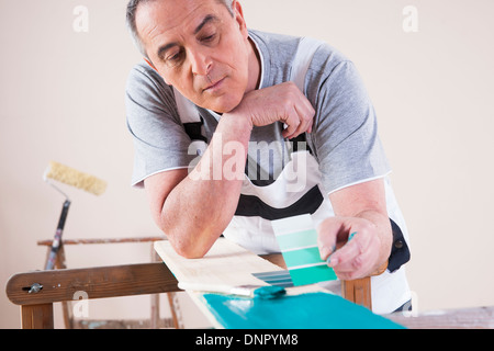 Senior woman Vergleich Lackmuster gemalten Board, Studioaufnahme Stockfoto