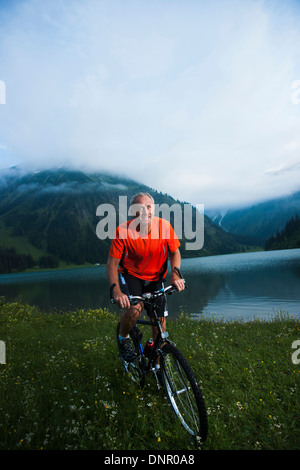Reifer Mann Reiten Mountainbike von Vilsalpsee Tannheimer Tal, Tirol, Österreich Stockfoto