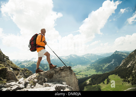 Reifer Mann steht auf Klippe, Wandern in Bergen, Tannheimer Tal, Österreich Stockfoto