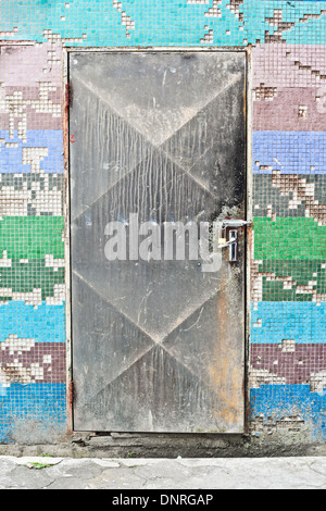 Metallische Tür in eine bunt gekachelte Wand gesperrt Stockfoto