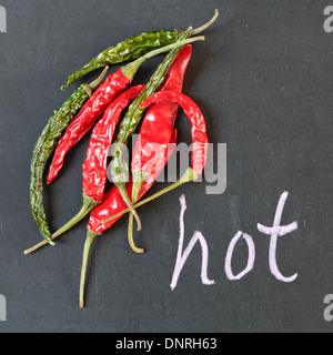 Grüne und rote Peperoni auf eine schwarze Fläche Stockfoto