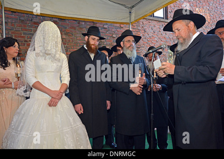 Eine orthodoxe religiöse jüdische Braut und Bräutigam unter einem Baldachin bei ihrer Trauung in Lubawitsch-Zentrale in Brooklyn, New York Stockfoto