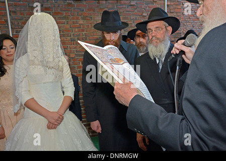 Eine orthodoxe religiöse jüdische Braut und Bräutigam unter einem Baldachin bei ihrer Trauung in Brooklyn, New York Stockfoto