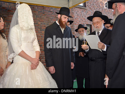 Eine orthodoxe religiöse jüdische Braut und Bräutigam unter einem Baldachin bei ihrer Trauung in Lubawitsch-Zentrale in Brooklyn, New York Stockfoto