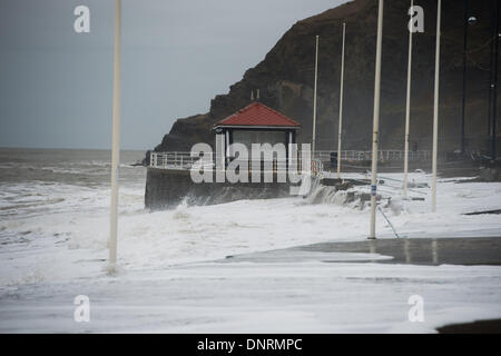 Aberystwyth Wales UK Pfund Sonntag, 5. Januar 2014 am Sonntagmorgen bei Flut, dramatischere Wellen bereits angeschlagenen Seafron in Aberystwyth.   Aberystwyth Promenade ist übersät mit Schutt nach Tagen von Fluten und Stürmen. Ein Großteil der Küste durch das schlagen der Wellen stark beschädigt wurde, mit der voraussichtlichen Kosten für die Reparaturen in Millionenhöhe Pfund photo Credit: Keith Morris/Alamy Live-Nachrichten Stockfoto