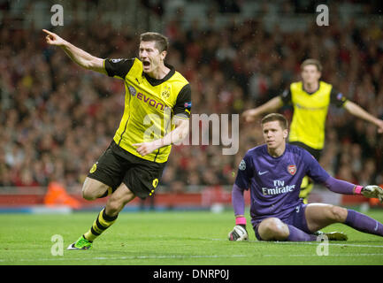 Datei - Datei Foto datiert 22. Oktober 2013 zeigt Robert Lewandowski von Borussia Dortmund jubeln neben Arsenals Torhüter Wojciech Szczesny während der Champions League-Spiel gegen FC Arsenal in London, Großbritannien. Borussia Dortmund-Stürmer Robert Lewandowski als erwartete Wechsel zu werden Rivalen FC Bayern München im Sommer nach der Unterzeichnung eines Fünf-Jahres-Vertrag, die Bundesliga-Meister 5. Januar 2014 bestätigt. Lewandowskis Vertrag mit Dortmund am Ende der Saison ausläuft und die 25-j hrige war frei, um ein Vorvertrag Geschäft seit dem 1. Januar. Foto: Bernd Thissen/dpa Stockfoto